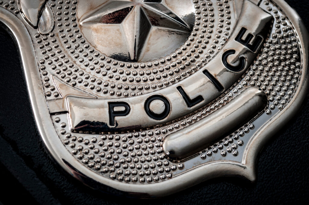 A close-up of a silver police badge lying on a table