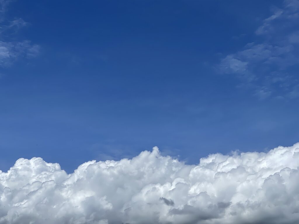 Puffy clouds across a very blue sky