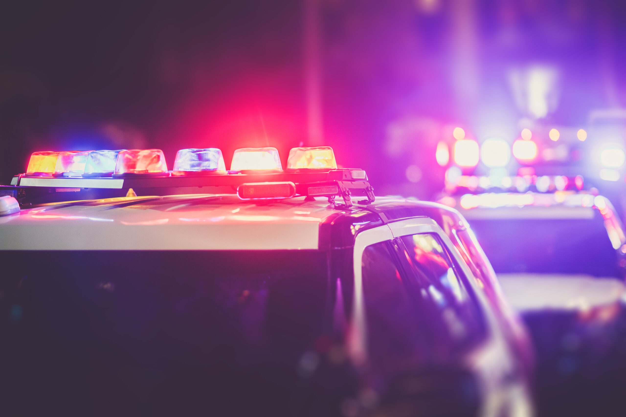 Police cars with flashing lights on top pulled over on the road
